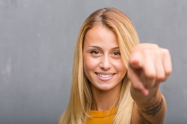 portrait de jeune femme blonde naturelle joyeuse et souriante pointant vers l'avant
 - Photo, image