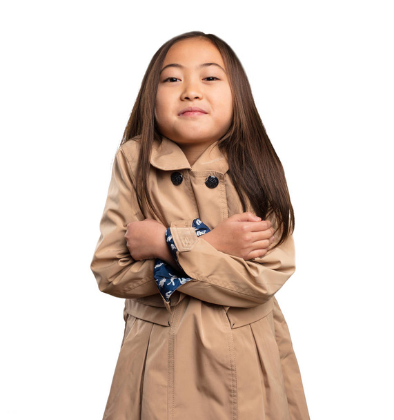 китайская маленькая девочка в бежевом пальто с холодным изолированным на белом фоне
 - Фото, изображение