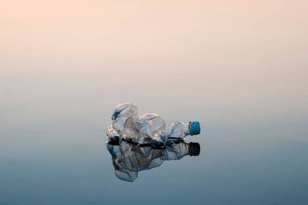 Concept of pollution, creative background. A plastic bottle floating in the ocean, non-decomposable plastic, pollution of the environment. - Valokuva, kuva
