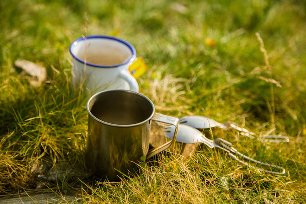 Δύο μεταλλικά κύπελλα με τσάι στο βουνό. Το πρωινό σε εξωτερικούς χώρους κατά τη διάρκεια της πεζοπορίας. Όρη Τάτρα, Σλοβακία, Ευρώπη. - Φωτογραφία, εικόνα