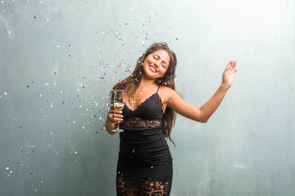 junge lateinische Frau feiert Neujahr oder Ereignis und hält Champagner in der Hand - Foto, Bild