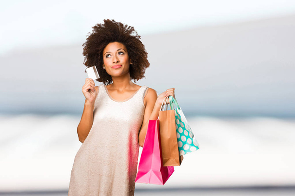 jonge zwarte vrouw gaan winkelen op achtergrond wazig - Foto, afbeelding