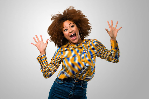Afro woman being surprised and shocked - Foto, afbeelding