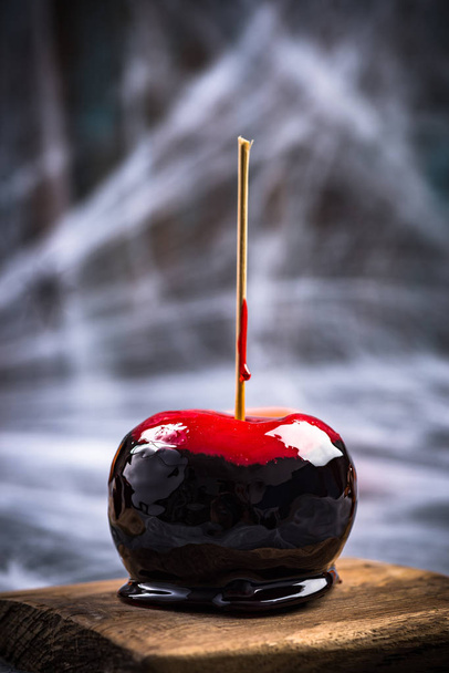 Застекленное яблоко конфеты, черное и красное. Творческая еда для вечеринок
. - Фото, изображение
