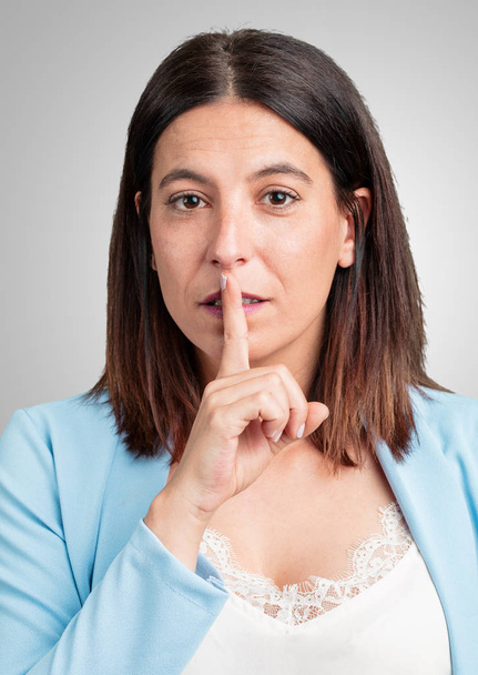 Kobieta w średnim wieku zachowanie tajemnicy lub prosi o ciszę, poważny wyraz twarzy, pojęcie posłuszeństwa - Zdjęcie, obraz