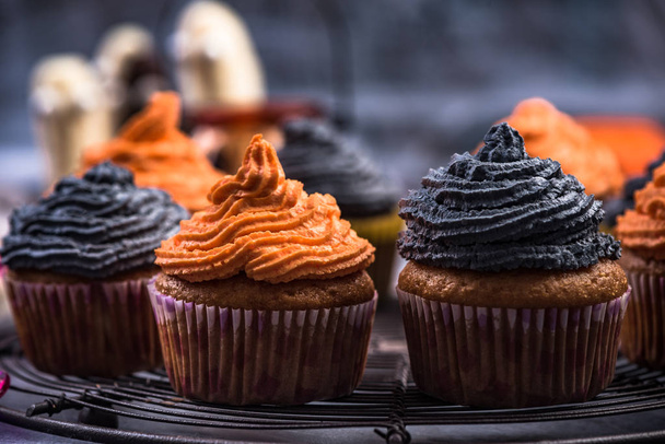 Schwarze und orangefarbene Cupcakes für Halloween. - Foto, Bild