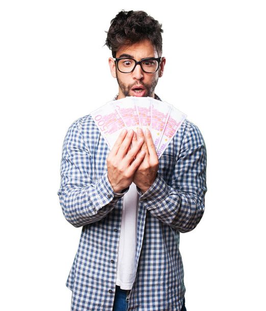 happy young man holding bills isolated on white background - Foto, afbeelding