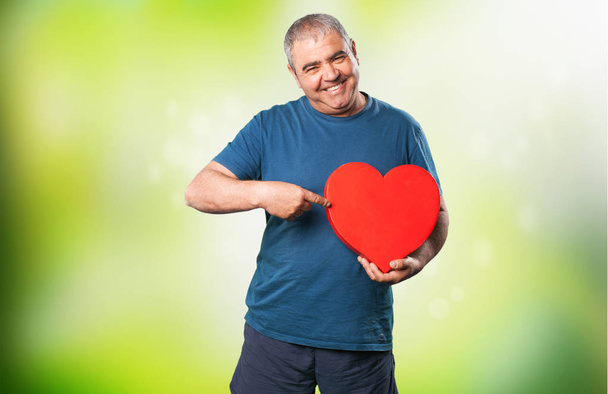 зрілий чоловік тримає форму серця
 - Фото, зображення