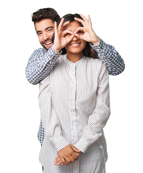 jovem casal fazendo um gesto óculos
 - Foto, Imagem