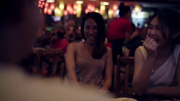 Movimento lento - Jovens mulheres asiáticas viajando mochileiros bebendo álcool ou cerveja e dançando com amigos em festa noturna urbana em restaurantes em Bangkok, Tailândia. Conceito de viajante e turista
. - Filmagem, Vídeo