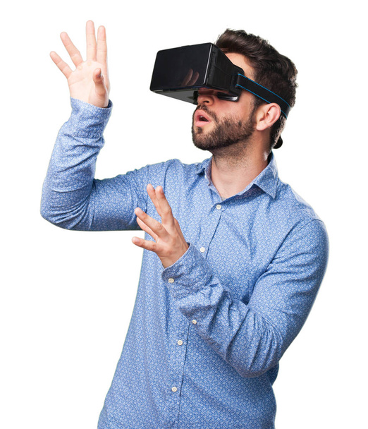 молодой человек смотрит через очки виртуальной реальности изолированы на белом фоне
 - Фото, изображение