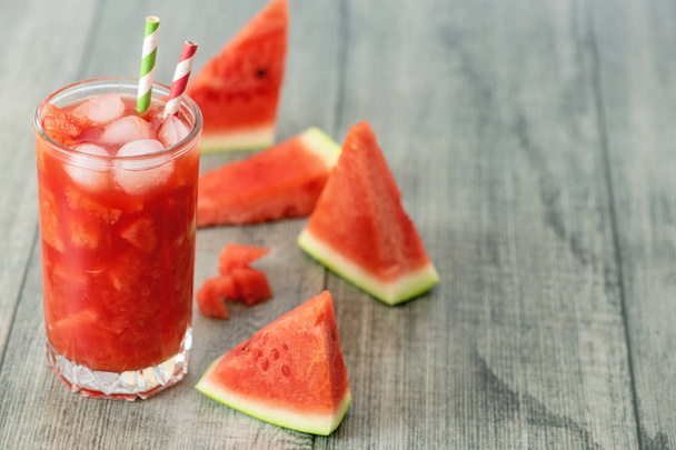 Watermelon smoothie in jars with fresh watermelon slices on gray wooden background. Copy Space. - Zdjęcie, obraz