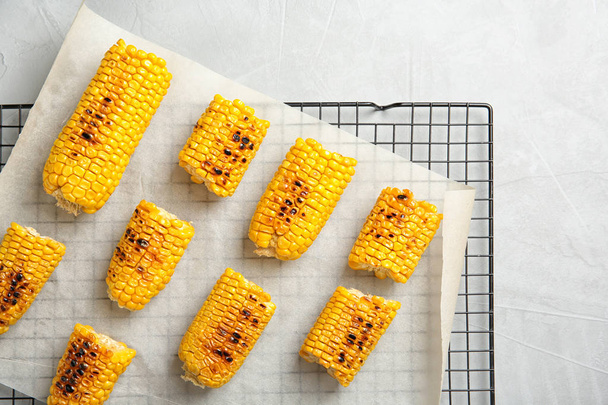 Cooling rack with grilled corn cobs on light background, top view - Photo, Image