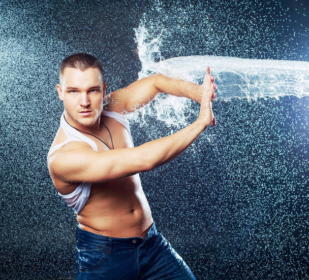 attractive young man with wet clothes  with a splash of water, studio photoshoot - Foto, afbeelding