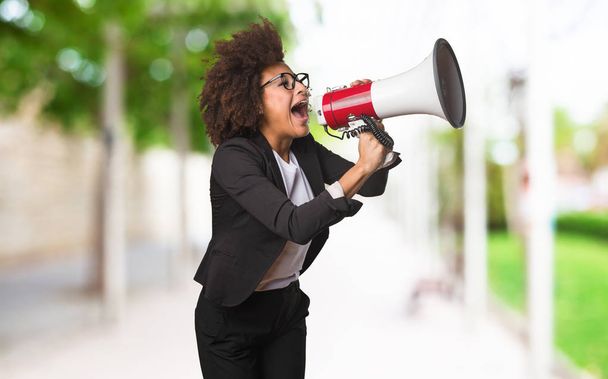 black business woman shouting on the megaphone on blurred background - Φωτογραφία, εικόνα