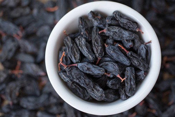 black raisins in white bowl - Foto, Imagen