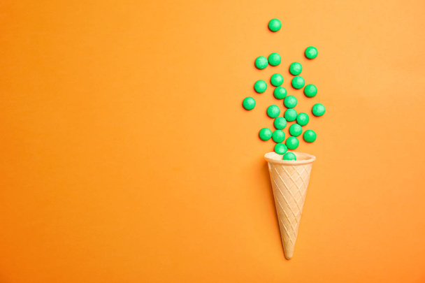 Flat lay composition with candies and ice cream cone on color background. Space for text - Fotografie, Obrázek