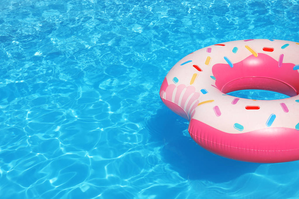 Inflatable ring floating in swimming pool on sunny day. Space for text - Fotoğraf, Görsel