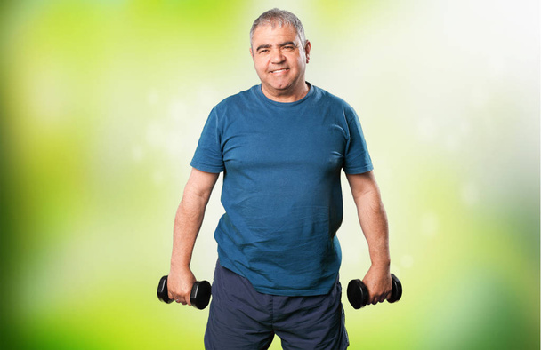 взрослый мужчина делает упражнения с гантелями
 - Фото, изображение