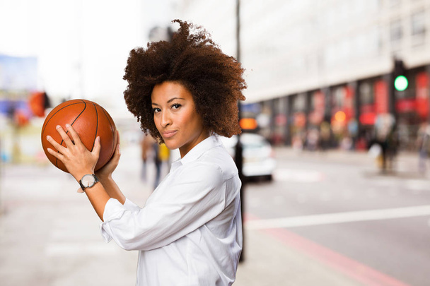 背景をぼかした写真にバスケット ボールを保持している若い黒人女性 - 写真・画像