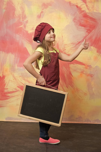 small happy girl chef in hat, apron with blackboard - Valokuva, kuva