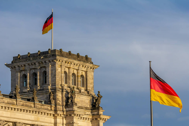 Федеративная Республика Германия, германский национальный флаг у здания парламента, машущий на голубом фоне неба
 - Фото, изображение