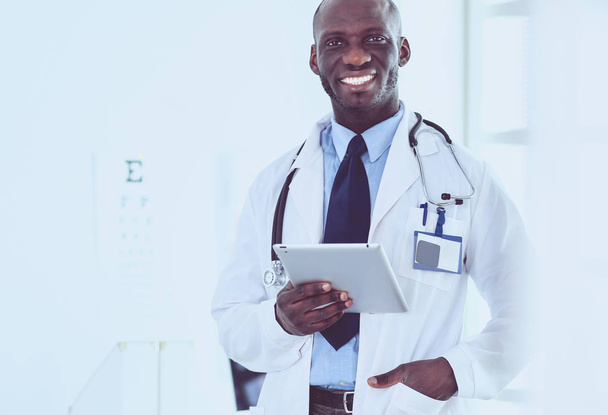 Male black doctor worker with tablet computer standing in hospital - Fotoğraf, Görsel