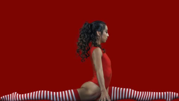 Genç kadın kırmızı jimnastik vücutta egzersizleri yapıyor  - Video, Çekim