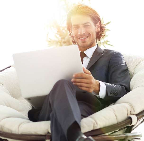 successful businessman with laptop sitting in a large comfortable armchai - Foto, Bild