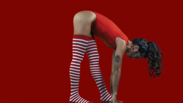 Genç kadın kırmızı jimnastik vücutta egzersizleri yapıyor  - Video, Çekim