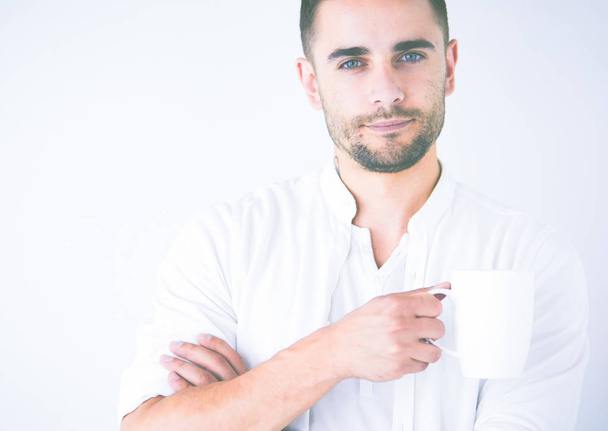 Young business man drinking a cup of coffee or tea - Фото, изображение