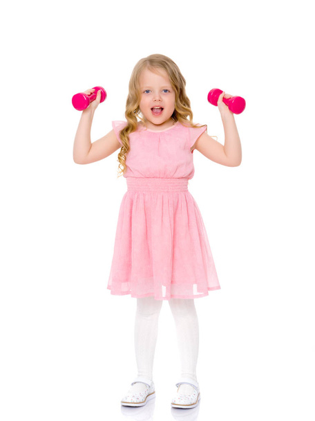 Little girl doing exercises with dumbbells. - Zdjęcie, obraz
