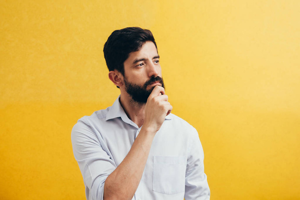 pensive bearded man on a yellow background - Фото, изображение