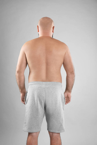 Fat man on grey background. Weight loss - Foto, imagen