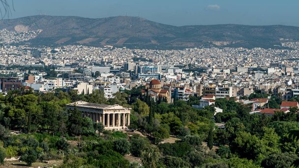 Hefaistoksen temppeli, jota ympäröivät muinainen Agora ja nykyaikainen Ateena, taustalla Parnasas-vuori
 - Valokuva, kuva