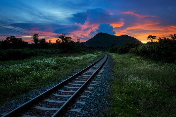 Σιδηροδρομικές ή πιέζει ενάντια όμορφο βράδυ ουρανό στο ηλιοβασίλεμα, βιομηχανικό τοπίο στην εξοχή. - Φωτογραφία, εικόνα