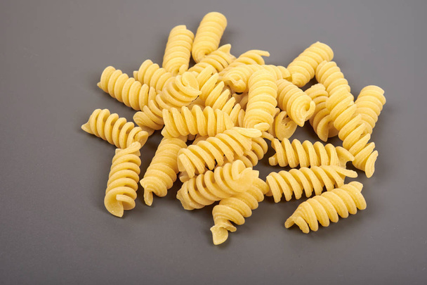 uncooked fusilli pasta noodles isolated on grey background - Foto, Bild