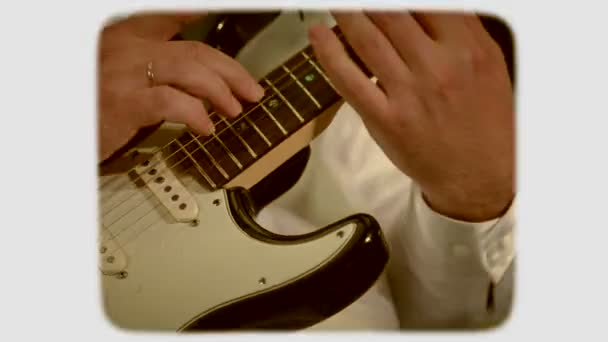 El üzerinde beyaz bir elektrik gitar çalıyor. 8mm retro tarzı film. - Video, Çekim