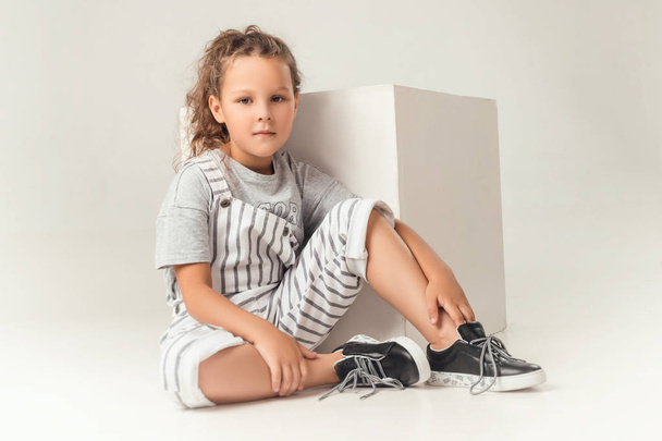 ребенок в студии позирует в модной одежде
 - Фото, изображение