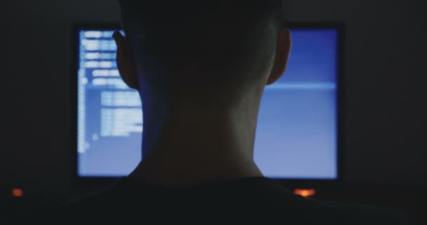 hacker werkt op een computer in een donkere kantoorruimte. - Video
