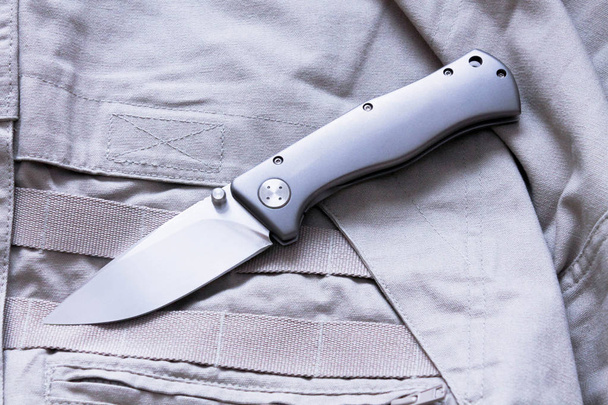 Pocket knife on cloth background. Sharp blade. - Photo, Image
