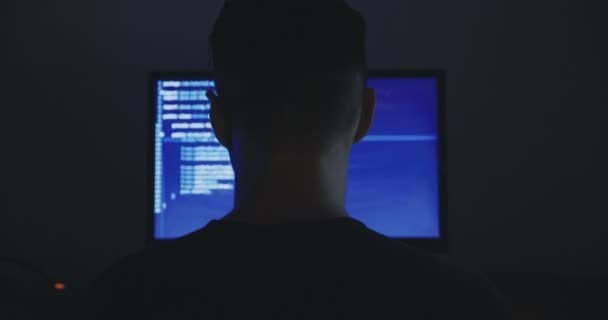 マップの暗いオフィスの部屋で画面上のデータとコンピューターで動作する男性ハッカー. - 映像、動画