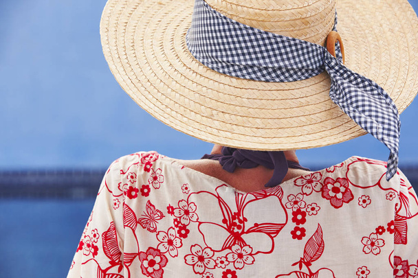 Summer time. Woman with hat and blue water background. Relaxing - Photo, Image