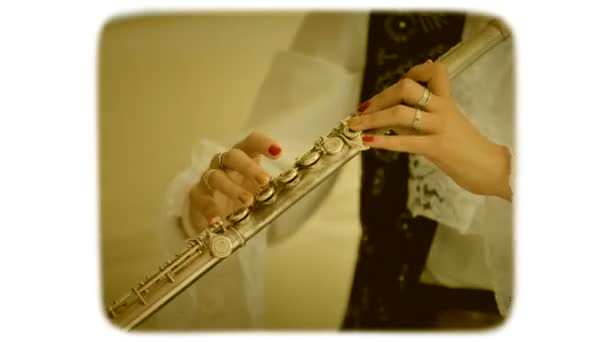 Dedos femeninos tocando los botones de la flauta. Película de estilo retro de 8mm
. - Imágenes, Vídeo