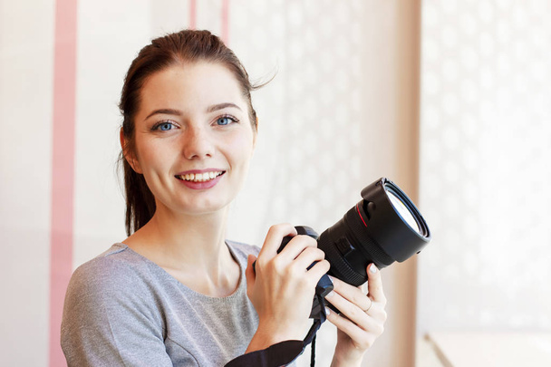 Portrait of Girl photographer smiling and holding her camera  - Foto, afbeelding