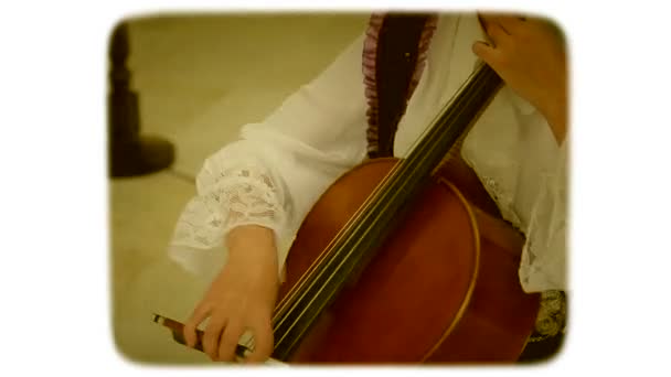 A woman with a bow drives the strings of a double bass. 8mm retro style film. - Footage, Video