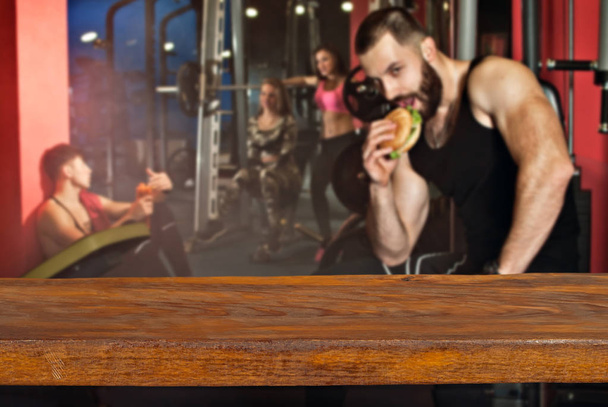 Product display montage Concept. Empty wood table space platform and fitness gym background. Athletes are trained on a blurred background. - Fotografie, Obrázek