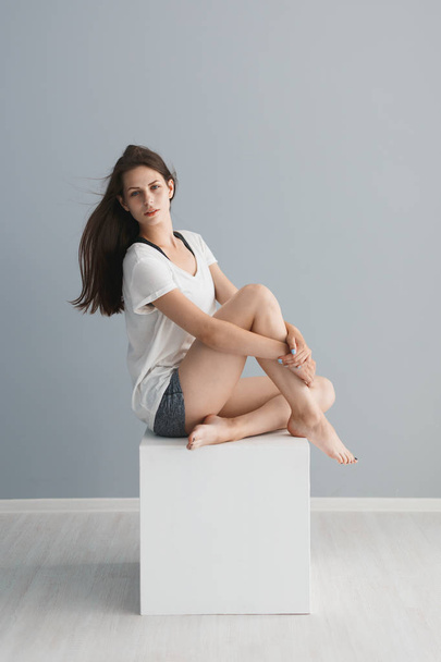 Portrait of a beautiful girl in the studio on a gray background - Fotografie, Obrázek