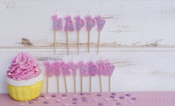 Colorful birthday cupcake with text on wooden background - 写真・画像