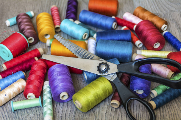 Multi Colored Thread Yarns and Vintage Scissors on Wooden Background - Fotó, kép